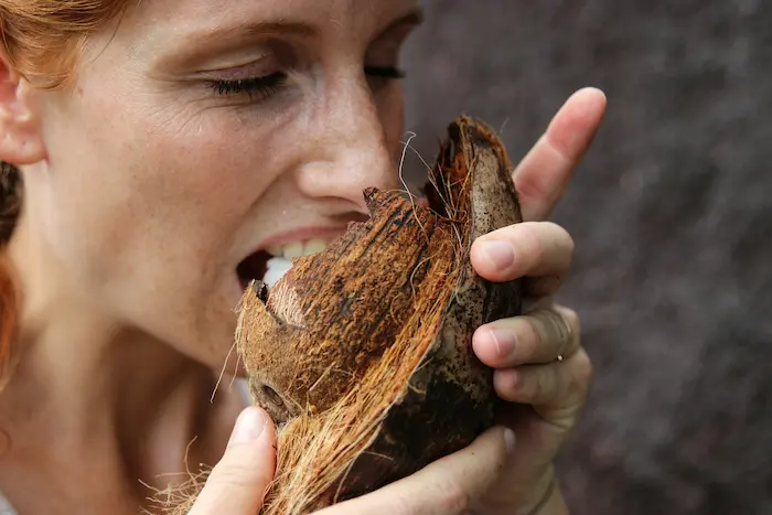 mujer mordiendo un coco